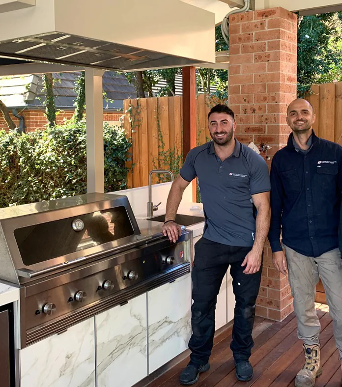 Our smiling team members standing in an outdoor barbecue area