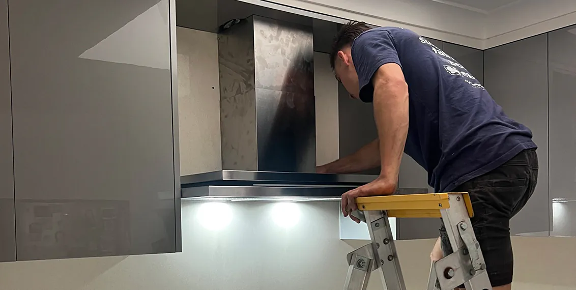 A Sydney Rangehoods' team member troubleshooting a rangehood issue.