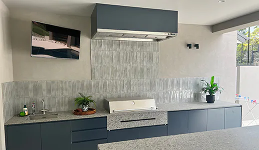 A beautiful black and silver rangehood in an alfresco area, providing a stylish and efficient ventilation solution for outdoor cooking