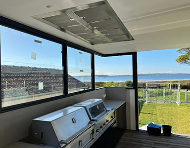A large cassette style rangehood in an alfresco area, providing a sleek and efficient ventilation solution for outdoor cooking