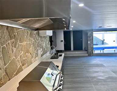 A large new stainless alfresco rangehood in an outdoor pool area, designed for effective ventilation in open spaces