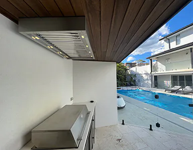 A nice stainless alfresco rangehood next to a pool, designed for effective ventilation in outdoor cooking areas