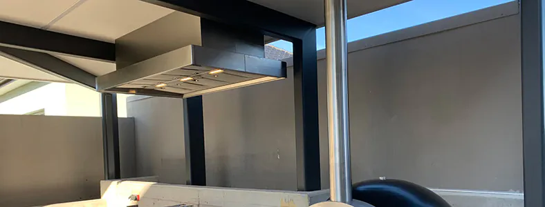 An amazing canopy style alfresco stainless rangehood in a beautiful barbecue area, enhancing outdoor cooking with style and efficiency