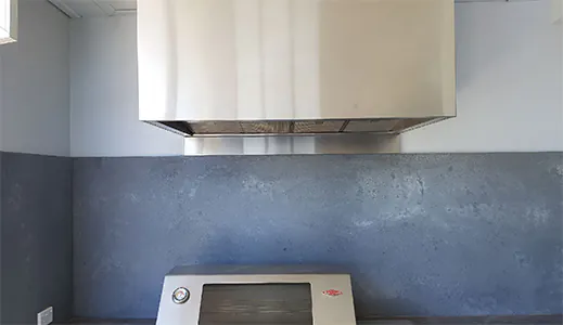 A new stainless canopy rangehood in an outdoor cooking area