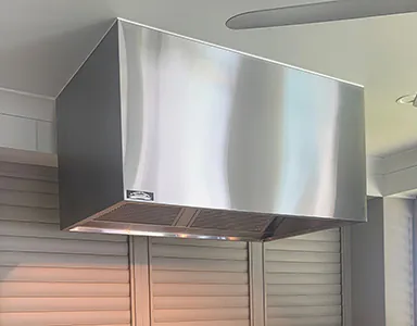A beautiful stainless canopy rangehood perfectly integrated into a modern kitchen
