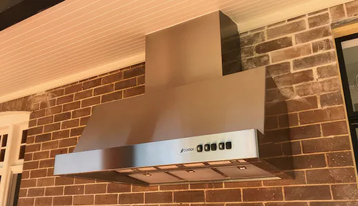 A large stainless steel canopy rangehood installed outdoors