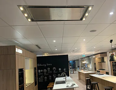 A ceiling cassette rangehood in a kitchen display centre, showcasing its sleek design and efficient ventilation capabilities