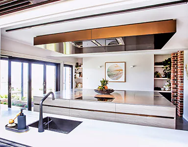 A very stylish ceiling cassette style rangehood in a bright open kitchen, enhancing the modern aesthetic with its sleek design