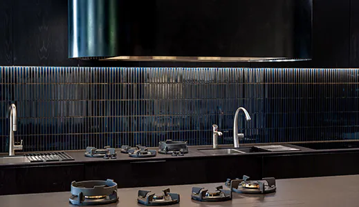 A large black island rangehood in a beautiful dark modern kitchen, providing a bold statement and effective ventilation