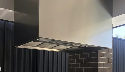 A large stainless steel island rangehood in an outdoor area, designed for optimal ventilation in open spaces