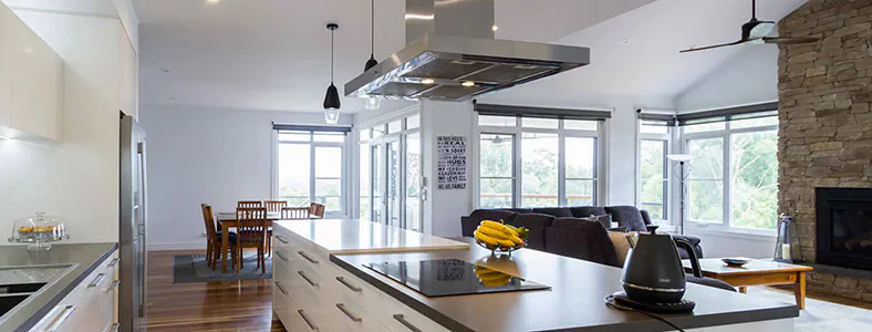 A beautiful example of a modern sleek island stainless steel rangehood in a spacious kitchen, enhancing the cooking area with style and functionality