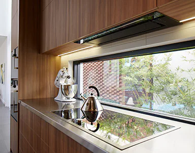 A beautiful black under mount rangehood in a wooden kitchen, providing a sleek and modern look