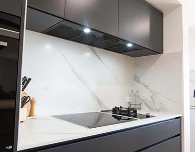 A sleek black under mount rangehood in a modern kitchen, designed for efficient ventilation and style