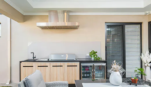 A brand new stainless wall mounted rangehood in a bright modern living area, enhancing the kitchen's aesthetic and functionality