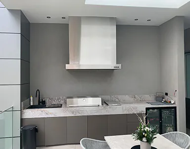 A new wall mounted stainless rangehood in a semi-outdoor cooking area, designed for effective ventilation