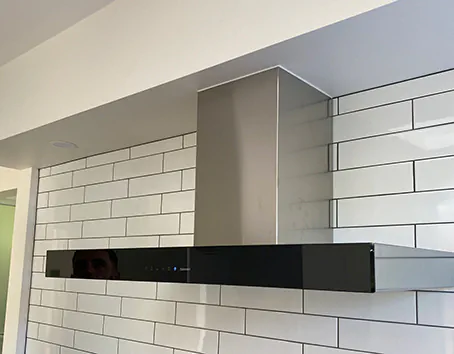 A Qasair under-mount rangehood neatly hidden under a kitchen cabinet