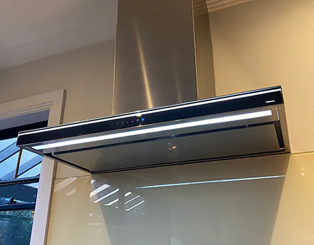 A white Qasair wall-mounted rangehood in a modern kitchen