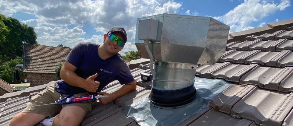 Our team fixing a rangehood exhaust fan on the roof