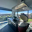 A beautiful large alfresco style rangehood in an outdoor kitchen