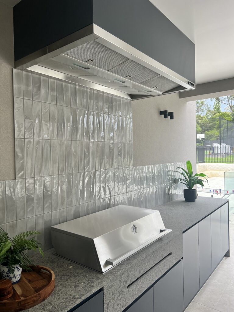 Side angle view showcasing the custom navy finish of the Qasair BBQ rangehood matching the cabinetry.