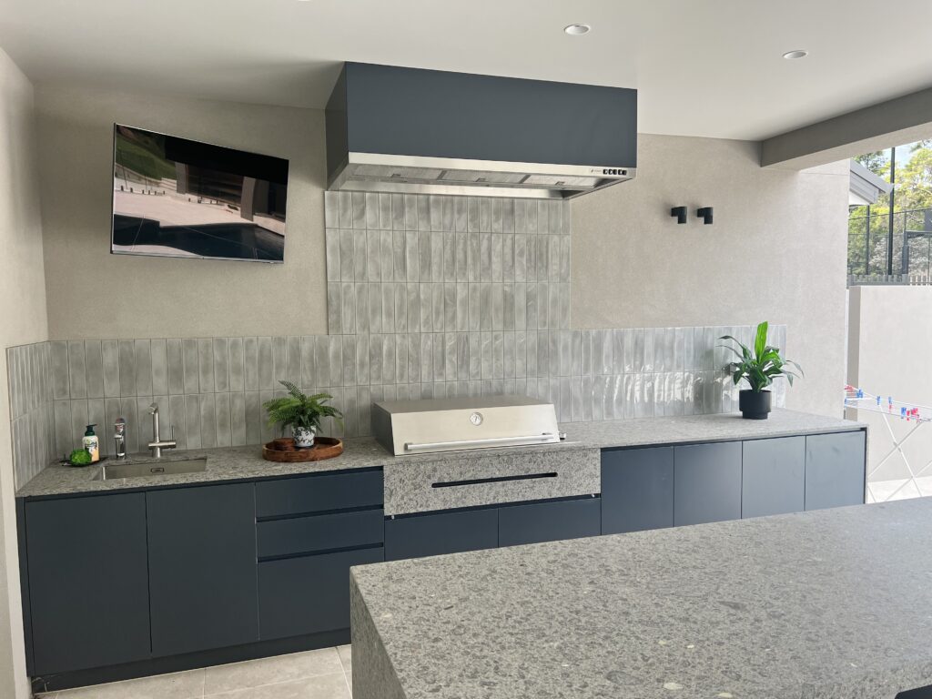 Qasair Austin BBQ rangehood set against a grey tile splashback with marble bench and gas bbq in Dural home.